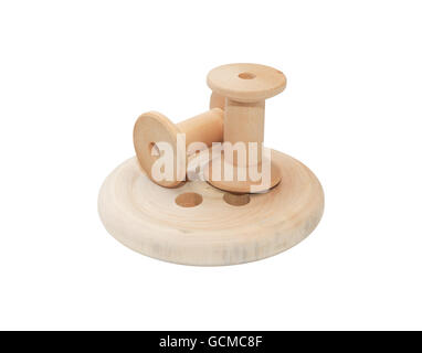Sewing concept. Two empty wooden spools on big button.  Isolated on white background with clipping path Stock Photo