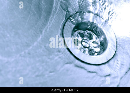 Closeup of metal kitchen sink with flowing water Stock Photo