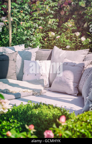 Image of cozy garden seating area with cushions. Stock Photo