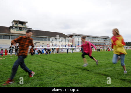 Horse Racing - The Surrey Mirror Family Day - Lingfield Park. Children take the opportunity to run along the course at Lingfield Racecourse prior to the 'Family Fun Race Day' Stock Photo