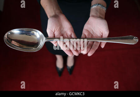 Lyon & Turnbull employee Elana Ratcheva holds Scotland's largest known silver spoon. The 370 gram early Queen Anne hash spoon, valued at 1,800, dates from 1703 and is to be auctioned on August 16th in Edinburgh. Stock Photo