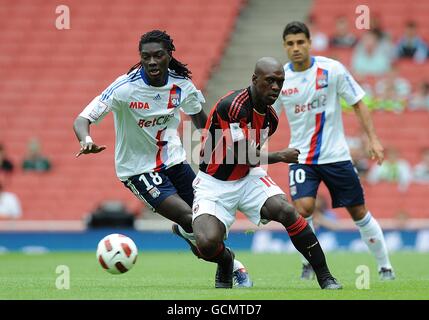 Olympique Lyonnais' Bafetimbi Gomis (left) and AC Milan's Clarence Seedorf (right) battle for the ball Stock Photo