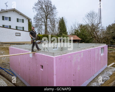 Prefabricated house, workers in setting up the basement walls Stock Photo