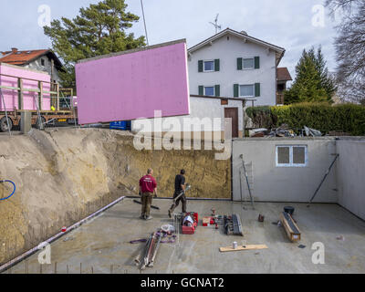 Prefabricated house, workers in setting up the basement walls Stock Photo