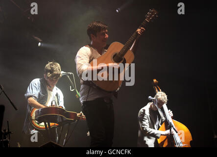 (Left to right) 'Country' Winston Marshall, Marcus Mumford and Ted Dwane of Mumford and Sons performing on the NME Radio 1 Stage at the Reading Festival. Stock Photo