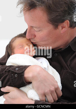 Prime Minister David Cameron holds his baby daughter, Florence Rose Endellion Cameron who was born on Tuesday August 24, during their summer holiday in Cornwall. Stock Photo