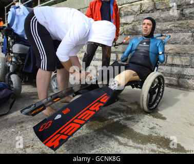 French limbless swimmer Philippe Croizon is helped by team member Valerie Carbonnel following a training session in Folkestone, Kent, before his attempt later this week to become the first limbless person to swim the Channel from Folkestone to France a distance of 21 miles. Stock Photo