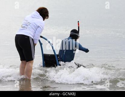 French limbless swimmer Philippe Croizon is helped into the sea by team member Valerie Carbonnel during a training session in Folkestone, Kent, before his attempt later this week to become the first limbless person to swim the Channel from Folkestone to France a distance of 21 miles. Stock Photo