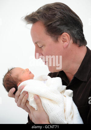 Previously unreleased photo of Prime Minister David Cameron holding his baby daughter, Florence Rose Endellion Cameron who was born on Tuesday August 24, during their summer holiday in Cornwall. Stock Photo