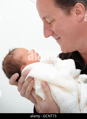 Previously unreleased photo of Prime Minister David Cameron holding his baby daughter, Florence Rose Endellion Cameron who was born on Tuesday August 24, during their summer holiday in Cornwall. Stock Photo