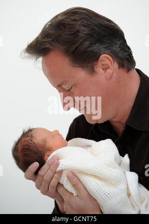 Previously unreleased photo of Prime Minister David Cameron holding his baby daughter, Florence Rose Endellion Cameron who was born on Tuesday August 24, during their summer holiday in Cornwall. Stock Photo