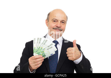 elderly man in a suit holding money and showing thumbs up Stock Photo