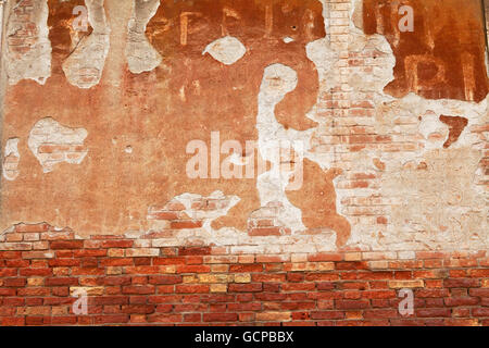 Decaying plaster on a city wall creates a threatening image. Stock Photo
