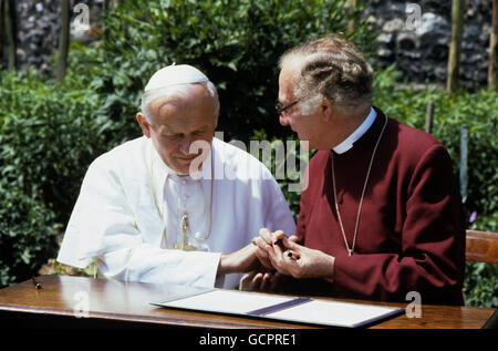 Pope John Paul II (left) acknowledges the Archbishop of Canterbury, Dr. Robert Runcie (right) as they sit in the grounds of the Deanery of the cathedral to sign a declaration to set up a new Anglican-Roman Catholic International Commission to examine the doctrinal differences which separate the two churches. Stock Photo