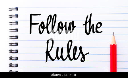 Follow The Rules written on notebook page with red pencil on the right Stock Photo