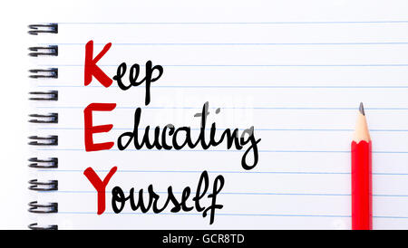 KEY Keep Educating Yourself written on notebook page with red pencil on the right Stock Photo