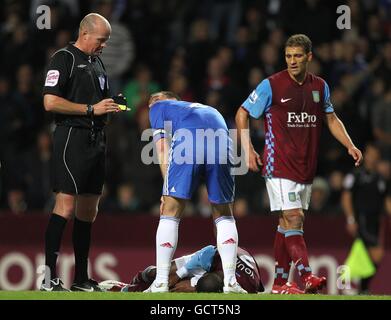Chelsea's John Terry (centre) checks on Aston Villa's Ashley Young (floor) following a challenge as referee Lee Mason (left) looks on Stock Photo