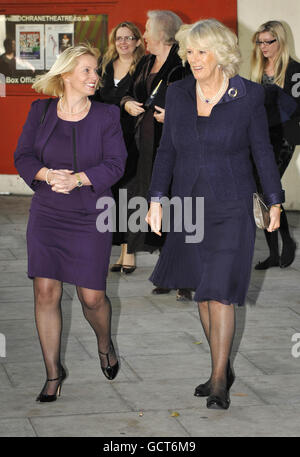 The Duchess of Cornwall (right), President of the National Osteoporosis Society smiles as she leaves the Cochrane Theatre in London, with charity CEO Claire Severgnini, where she attended a 'Body Gossip' performance to mark World Osteoporosis Day. Stock Photo