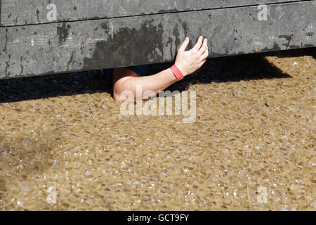 A participant is participating at an extreme sport challenge near Sofia. The sports event is mud and obstacle course designed to Stock Photo