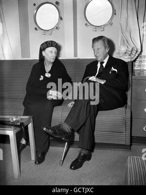 Poet Sir Osbert Sitwell with his sister Dame Edith Sitwell, poet, critic, lecturer and wit, as she arrives at Southampton on aboard the liner United states from America, where she has been giving readings of her poetry. On a visit to Hollywood, Dame Edith met Marilyn Monroe, brought from the film star the comment 'I think she is one of the most wonderful women I've ever met'. Stock Photo