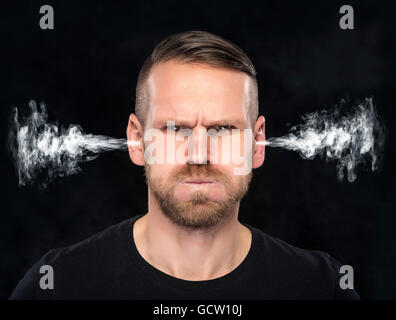 Angry man with smoke or fume coming out from his ears on dark background. Stock Photo