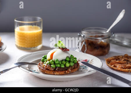 delicious and healthy breakfast - sandwich with onion jam, poached egg, peas and bacon Stock Photo