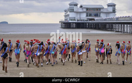 Finalists of the Miss Great Britain beauty pageant walk on the beach beside Weston-super-Mare Pier in -2 degrees C wearing one piece swimsuits. Stock Photo