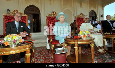 Britain's Queen Elizabeth II, the Duke of Edinburgh(left) the Sultan of Oman, His Majesty Sultan Qaboos bin Said and British Foreign Secretary of State, William Hague (right) sit as they watch an equestrian event and horse racing, at the Royal Horse Racing Club in Seeb Oman. Stock Photo