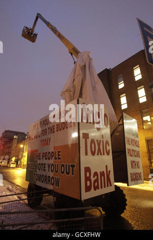 A cherry picker covered with a number of slogans attacking politicians and the banking sector to protest outside the gates of Leinster House, Dublin on Budget day. PRESS ASSOCIATION Photo. Picture date: Tuesday December 7, 2010. A lone demonstrator parked the crane near the Dail. The control panel was sealed off, preventing gardai from bringing the protester back to ground. See PA story IRISH Budget Protests. Photo credit should read: Niall Carson/PA Wire Stock Photo