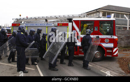 Specialist prison officers escort fire fighters in to HMP Ford near Arundel, West Sussex after about 40 prisoners began a riot and set alight the open prison, according to the Ministry of Justice. Stock Photo