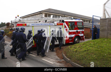 Specialist prison officers escort fire fighters in to HMP Ford near Arundel, West Sussex after about 40 prisoners began a riot and set alight the open prison, according to the Ministry of Justice. Stock Photo