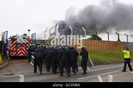 Specialist prison officers escort fire fighters in to HMP Ford near Arundel, West Sussex after about 40 prisoners began a riot and set alight the open prison, according to the Ministry of Justice. Stock Photo