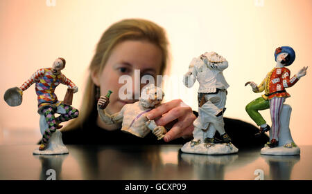 Katherine Boyle of Bonhams examines a porcelain figure which will go on sale on December 8 as part of a collection of fine Meissen Porcelain which was damaged by second world war bombing in Dresden after it was seized from Jewish collectors by the Nazis. Stock Photo