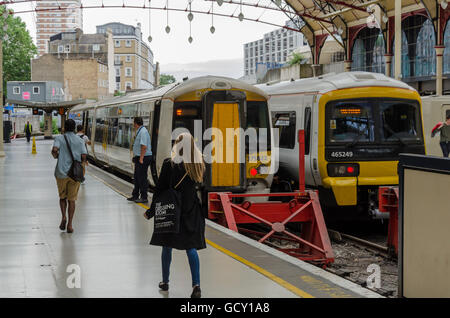 A couple of trains sit at the platforms in Victoria Station in London Stock Photo