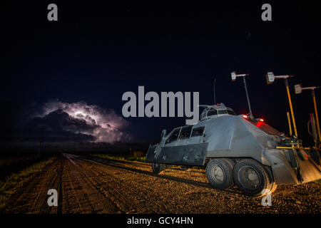 The storm chasers of the TIV 2 or 'Tornado Intercept Vehicle 2' prepare to drive towards a tornadic supercell at night. Stock Photo