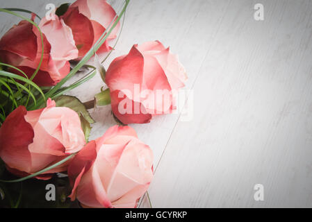 A bouquet of roses on a white wood old background. Vintage style. Stock Photo