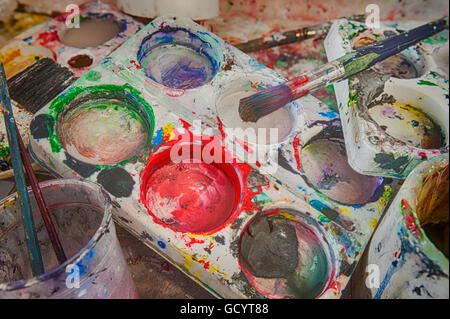 discarded left behind dirty paint brushes in butlers sink needing a serious clean and polish after messy art students painters Stock Photo