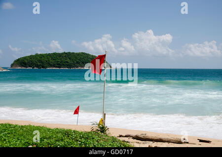 Beach warning red flags wind and wave rage at Nai Harn beaches of Phuket, Thailand Stock Photo