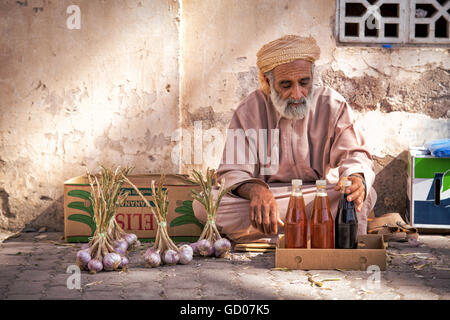 NIZWA, OMAN - APRIL 24 2015:Omani old man selling honey and garlic at the traditional market or souq in Nizwa, Oman Stock Photo