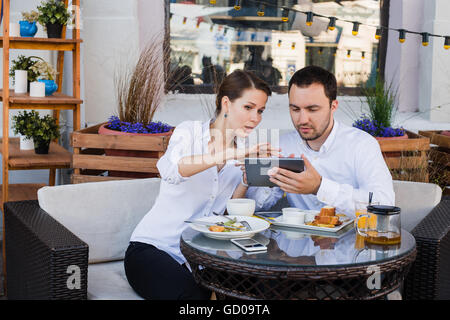 Business people looking at digital tablet in cafe during a meeting Stock Photo