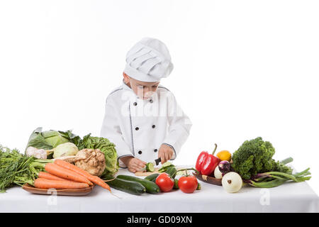 One little boy as chef cook making salad, cooking with vegetables. Isolated on white. Stock Photo