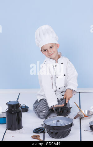 One little boy as chef cook making salad, cooking with vegetables. Isolated on white. Stock Photo