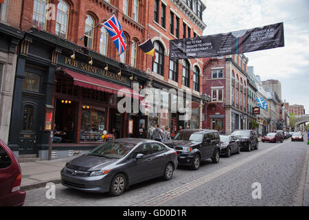 QUEBEC CITY - MAY 25, 2016: Rue St. Jean in old Quebec City is lined with quaint shops and restaurants which draw millions of to Stock Photo