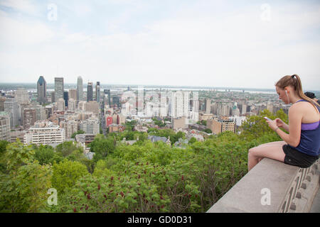 woman using cell phone on top of Mont Royal in Montreal city Stock Photo