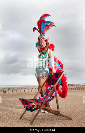 Blackpool, UK. 10th July, 2016. Showgirl 'Miss Informed' (Jenny Wilson) and knitters from around the UK were welcomed to Blackpool sea front to spin their own yarn in an attempt to break the Guinness World Record for simultaneous knitting.  The hardy wool warriors were faced with a blustery cool breeze but were able to knit themselves warm.  The current world record stands at 3089 people & with the assistance of the Town Crier 'Barry McQueen', new recruits were summoned from pavements & were more than happy to join in the fun. Credit:  Cernan Elias/Alamy Live News Stock Photo