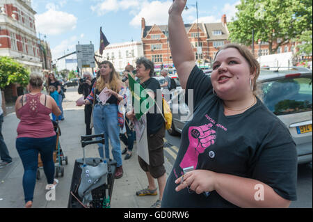 London, UK. 10th July 2016. Jasmin Stone of housing action group Focus E15 waves at the activists who have temporarily occupied the balconies of the former Police Station close to one of the entrances to the Mayor's Newham  Show. Credit:  Peter Marshall/Alamy Live News Stock Photo
