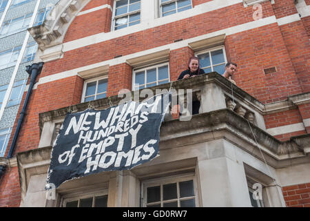 London, UK. 10th July 2016. Activists on one of the balcones of the former Police Station close to one of the entrances to the Mayor's Newham  Show with a banner 'Newham - Hundreds of Empty Houses'. Credit:  Peter Marshall/Alamy Live News Stock Photo