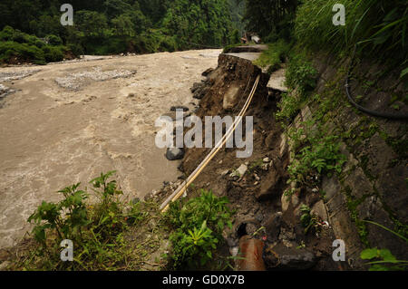 (160711) -- SINDHUPALCHOWK (NEPAL), July 11, 2016 (Xinhua) -- Photo taken on July 10, 2016 shows a road damaged by flood along the Bhotekoshi River in Sindhupalchowk, Nepal. The flood in the Bhotekoshi River has caused land erosion in multiple sections of Araniko Highway and swept way many houses in Tatopani and Liping. (Xinhua/Dinesh Bikram Shah) Stock Photo