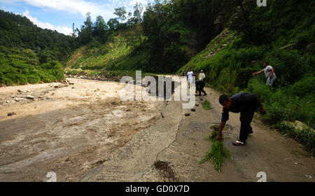 (160711) -- SINDHUPALCHOWK (NEPAL), July 11, 2016 (Xinhua) -- The police and local people place safety marks for travellers on a road damaged by flood along the Bhotekoshi River in Sindhupalchowk, Nepal, on July 10, 2016. The flood in the Bhotekoshi River has caused land erosion in multiple sections of Araniko Highway and swept way many houses in Tatopani and Liping. (Xinhua/Dinesh Bikram Shah) Stock Photo