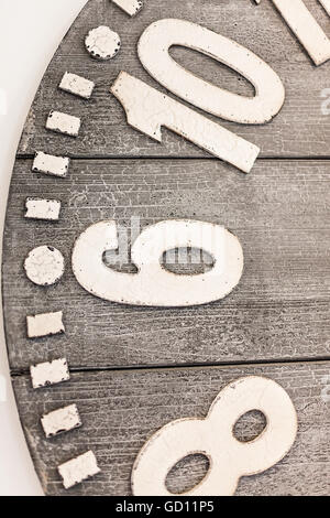 Closeup of a wooden watch half with embossed metal or 3d material numbers on the old and rough wooden face Stock Photo